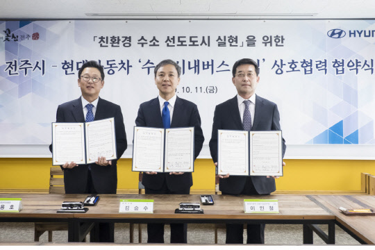 지난해 10월 11일 전주시청에서 진행된 '현대차-전주시 수소전기 시내버스 도입 업무협약(MOU)' 체결식에서 (왼쪽부터)문용호 전주시내버스공동관리위원회 이사장, 김승수 전주시장, 이인철 현대자동차 상용사업본부장이 기념촬영을 하고있다. <현대자동차 제공>